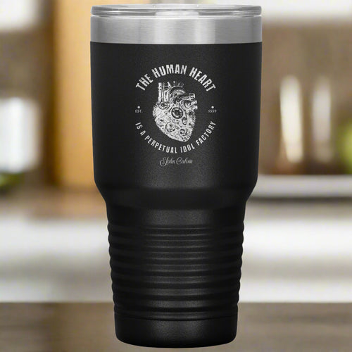 Black travel mug with metal lid featuring a mechanical heart design and text on a white background