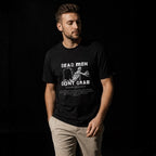 Dead Men Don't Grab black unisex tee on male model against dark backdrop