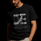 Close-up of Dead Men Don't Grab white skeleton and Voddie Baucham quote print on black tee