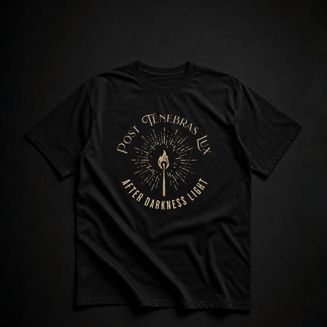 Black Post Tenebras Lux unisex T-shirt laid flat on a dark background, with gold torch artwork and After Darkness Light lettering.