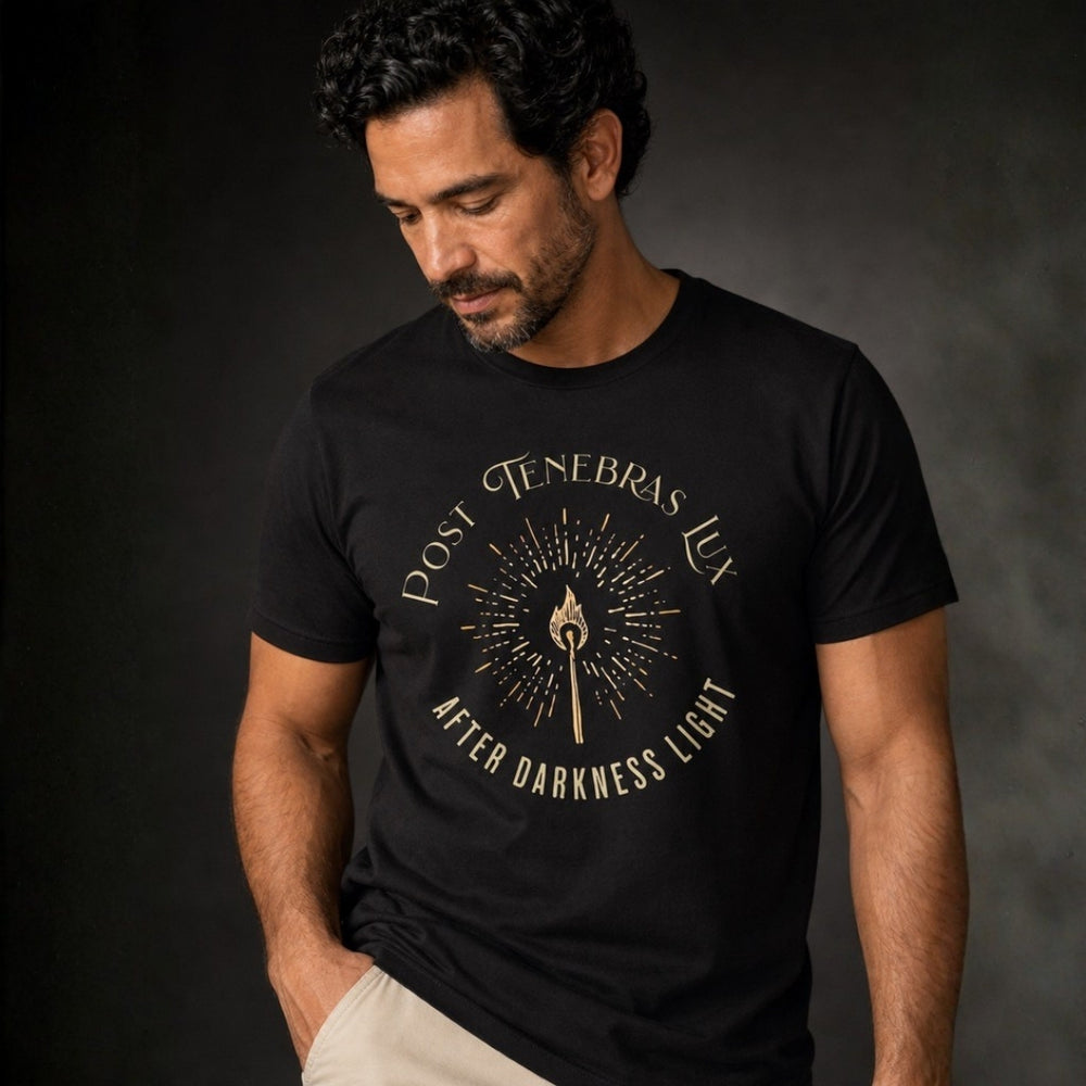 Close-up of man wearing black Post Tenebras Lux tee with gold After Darkness Light torch graphic.