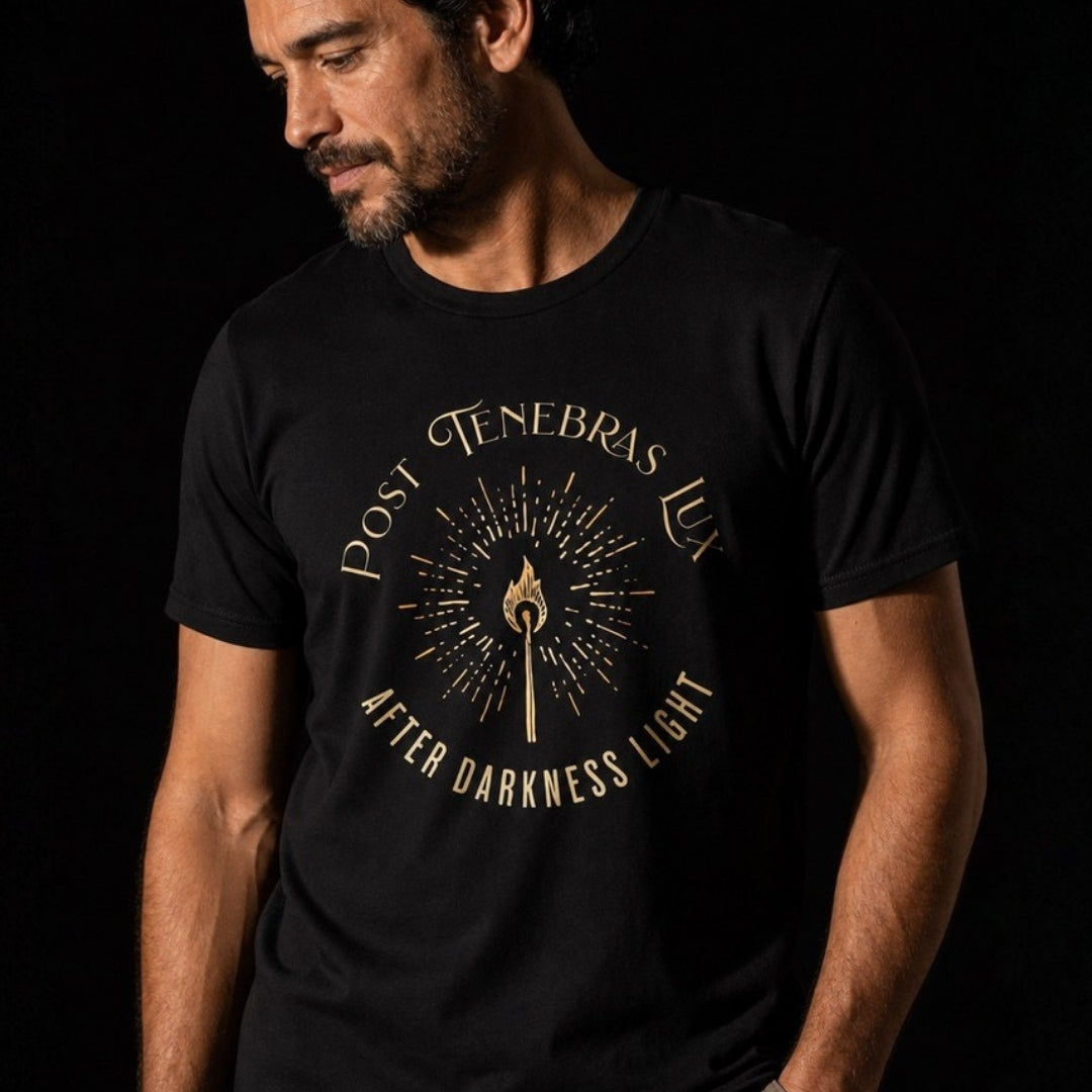 Detailed view of gold Post Tenebras Lux torch design on a black T-shirt worn by a man.
