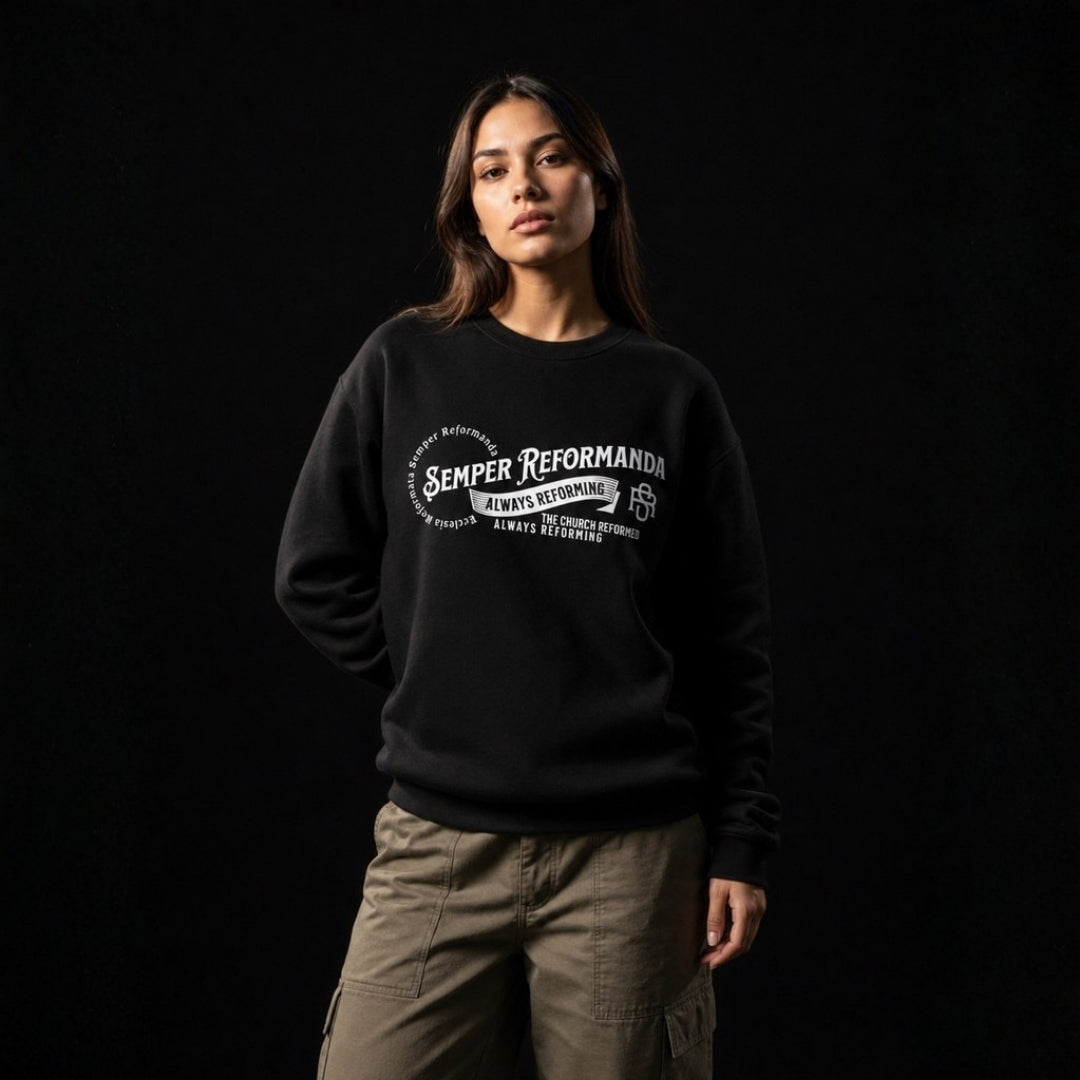 Woman wearing black Semper Reformanda sweatshirt against dark studio backdrop