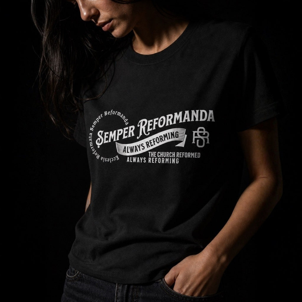 Woman wearing black Semper Reformanda unisex tee, close-up of white Always Reforming chest design
