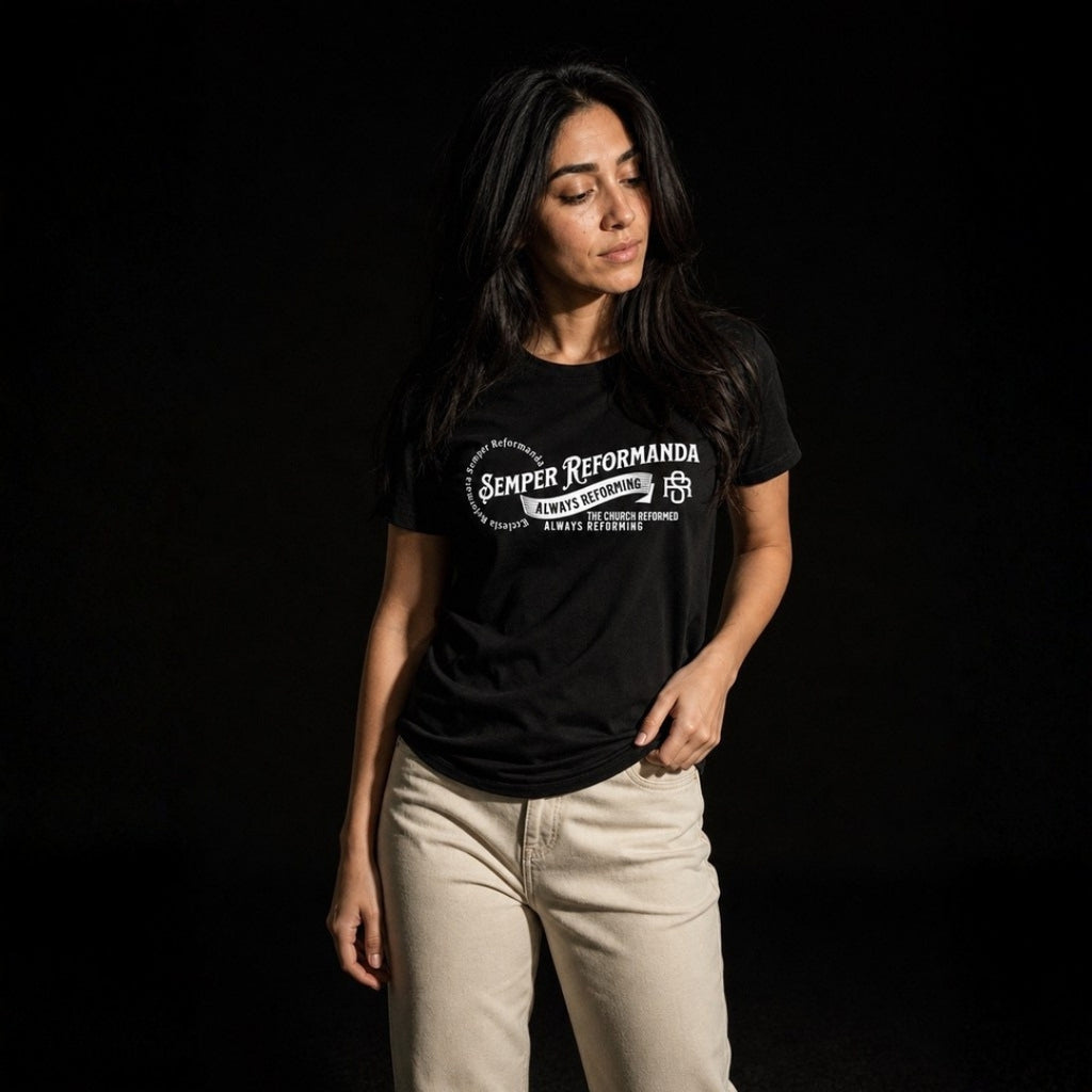 Woman modeling black Semper Reformanda unisex tee with cream pants on dark studio background