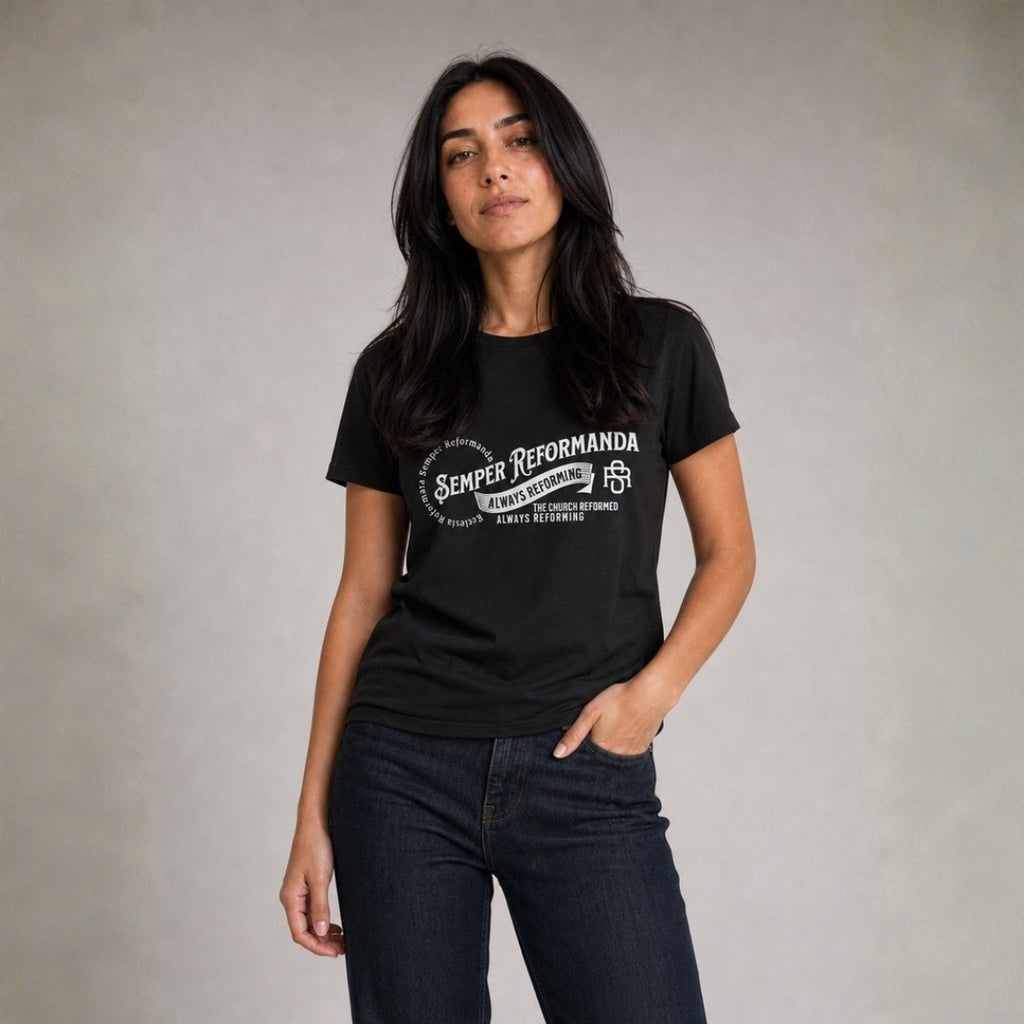 Woman wearing black Semper Reformanda unisex tee with jeans against light gray studio background