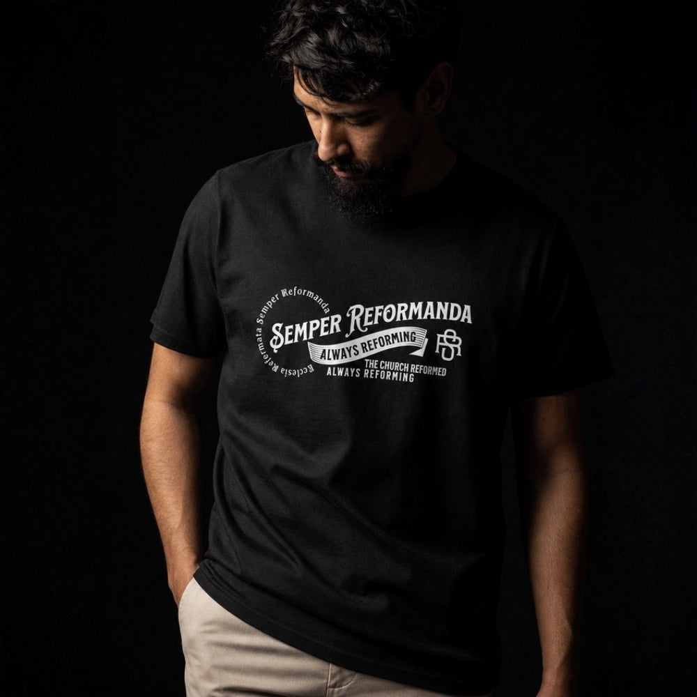 Close-up of man wearing black Semper Reformanda tee with white Reformed theology chest artwork