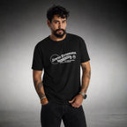 Man modeling black Semper Reformanda tee with white Always Reforming artwork on gray background