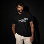 Man modeling black Semper Reformanda unisex tee against dark studio background